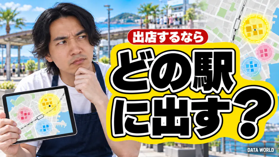 出店するなら、どの駅に出す？。晴れた海沿いの駅前の広場で、紺のエプロンをしたDATA TIMES編集長の小笠原海人が、あごに手を当てて疑うような顔をしている。手には3つの丸が描かれた地図のタブレット。右側に黄色い帯の上に大きく黒い文字で「どの駅に出す？」、その上の赤い札に「出店するなら」。